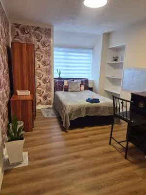 a bedroom with a bed and a chair in a room at Modern Oasis , Edinburgh Airport near,8mi in Rosyth