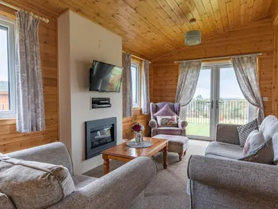 a living room with two couches and a fireplace at Chalet Loch Leven Lodge 21 by Interhome in Kinross