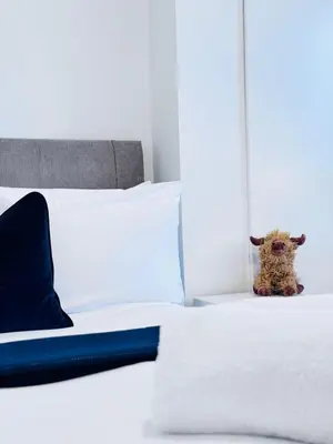 a stuffed animal sitting on a bed in a bedroom at Elegant City Centre Apartment in Edinburgh