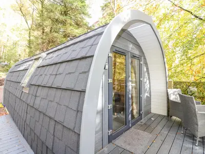 a dome house with an archway on a deck at Elleric Pods - The Last Resort in Appin