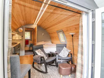 a tiny house with a wooden ceiling and a living room at Elleric Pods - The Last Resort in Appin