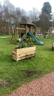 a park with a playground with a slide and a slideintend at North Lodge Holiday Home, Hot Tub & Sauna in Carnwath