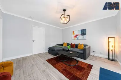a living room with a couch and a table at Cosy 2-Bed House I Easy Edinburgh Access I Sleeps 4 in Whitburn