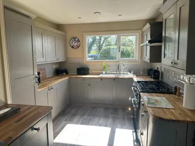a kitchen with white cabinets and a sink and a window at Ardenvhor - Loch Lomond in Gartocharn
