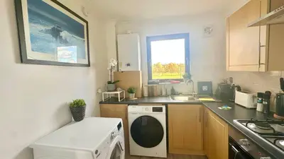a kitchen with a washing machine and a sink at Cosy stylish Duntocher flat near Glasgow in Clydebank