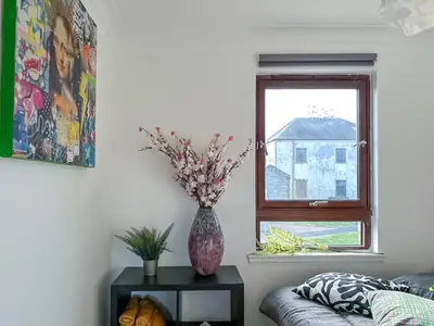 a vase sitting on a table next to a window at Cosy stylish Duntocher flat near Glasgow in Clydebank