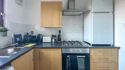 a kitchen with a stove and a sink at Cosy stylish Duntocher flat near Glasgow in Clydebank