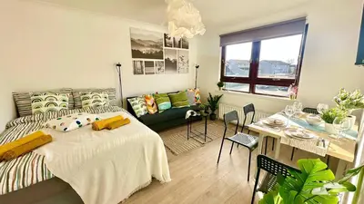 a bedroom with a bed and a living room at Cosy stylish Duntocher flat near Glasgow in Clydebank