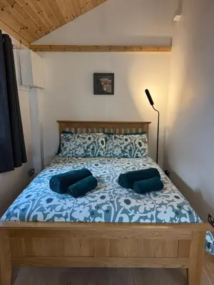 a bedroom with a bed with two blue pillows at Studio with a View in Onich