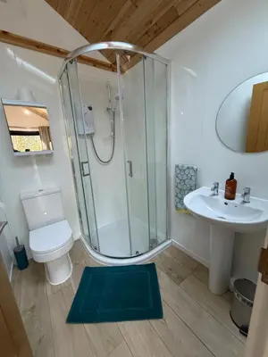 a bathroom with a shower and a toilet and a sink at Studio with a View in Onich