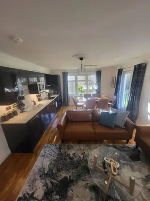 a living room with a couch and a kitchen at Turnberry Rest-Coorie Doon Stays in Turnberry