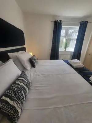 a large white bed with pillows and a window at Turnberry Rest-Coorie Doon Stays in Turnberry