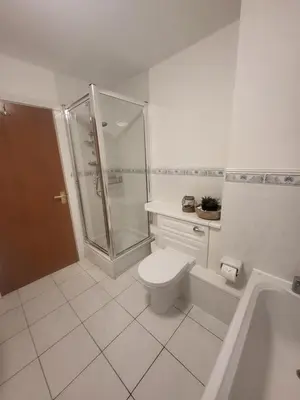 a white bathroom with a shower and a toilet at Turnberry Rest-Coorie Doon Stays in Turnberry