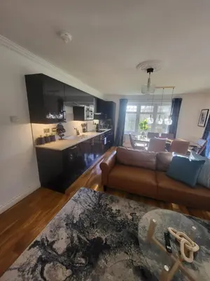 a living room with a couch and a kitchen at Turnberry Rest-Coorie Doon Stays in Turnberry