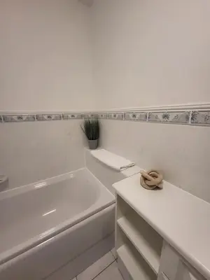 a white bathroom with a white tub and a sink at Turnberry Rest-Coorie Doon Stays in Turnberry