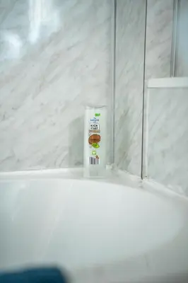 a bottle of toothpaste sitting on a shelf in a bathroom at 2 BDR House By Caledonia Luxe Stays Short Lets & Serviced Accommodation Bathgate in Bathgate