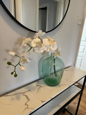 a glass vase sitting on a table in front of a mirror at Modern Economy Glasgow Apartment with King bed in Glasgow