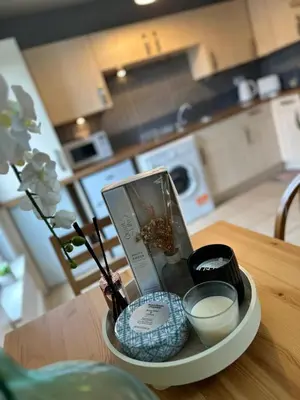a tray with cosmetics and candles on a table in a kitchen at Modern Economy Glasgow Apartment with King bed in Glasgow