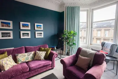 a living room with a purple couch and two chairs at Newly Renovated Flat in Trendy Finnieston in Glasgow