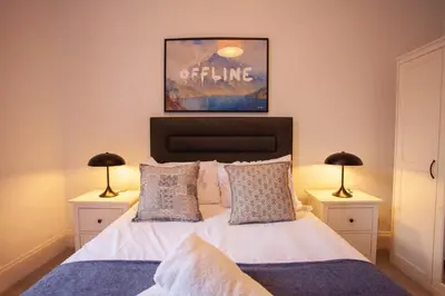 a bedroom with a bed with two lamps on tables at Newly Renovated Flat in Trendy Finnieston in Glasgow