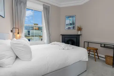 a white bed in a room with a window at GuestReady - Charming home in Edinburgh in Edinburgh