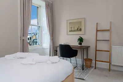 a room with two beds and a desk and a window at GuestReady - Charming home in Edinburgh in Edinburgh