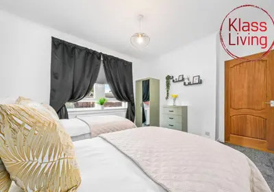 a bedroom with two beds and a dresser at Oxford Apartment by Klass Living in Coatbridge