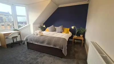 a bedroom with a large bed with yellow pillows at 5 Bedrooms Sleeps 10 Full Kitchen Parking in Ayr