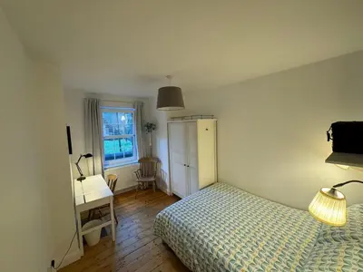 a bedroom with a bed and a desk and a window at Stirling Haven: Charming 3B Apt in City Centre in Stirling