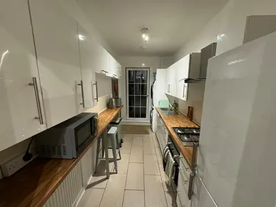 a kitchen with white cabinets and a microwave at Stirling Haven: Charming 3B Apt in City Centre in Stirling