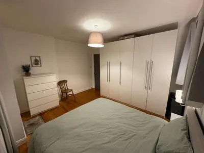 a bedroom with a large bed and a dresser at Stirling Haven: Charming 3B Apt in City Centre in Stirling