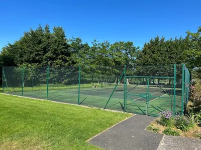 a tennis court with a gate in a park at Underwood House Garden Flat in Kilmarnock