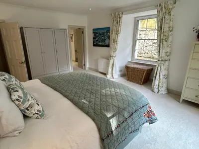 a bedroom with a bed and a window at Underwood House Garden Flat in Kilmarnock