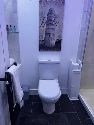 a bathroom with a toilet and a picture of the leaning tower at Modern 3-Bedroom Home with Cozy Cinema-Style Living Space in Cumbernauld
