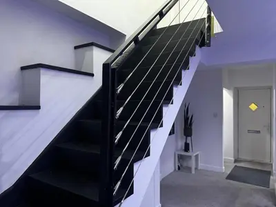 a black and white staircase in a house at Modern 3-Bedroom Home with Cozy Cinema-Style Living Space in Cumbernauld