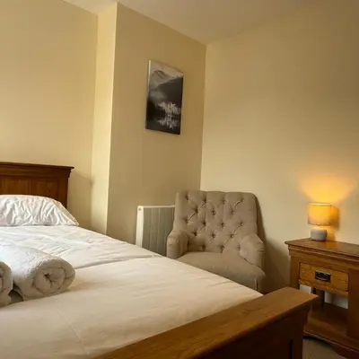 a bedroom with a bed and a chair at Mountain View House Kinlochleven in Kinlochleven