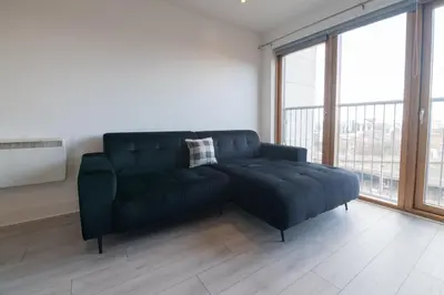 a black couch in a room with a large window at Argyle Place in Glasgow