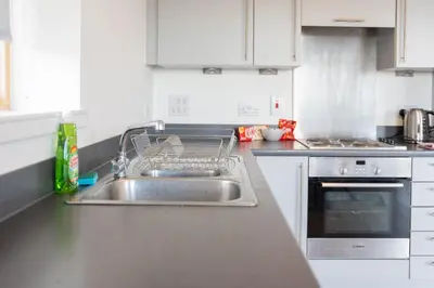 a kitchen with a sink and a stove at Argyle Place in Glasgow