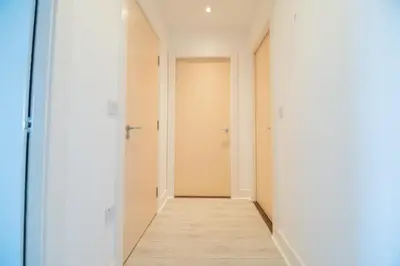 an empty corridor with white walls and a wooden floor at Argyle Place in Glasgow