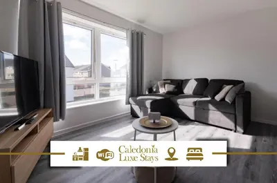 a living room with a couch and a large window at Renfrew House in Renfrew
