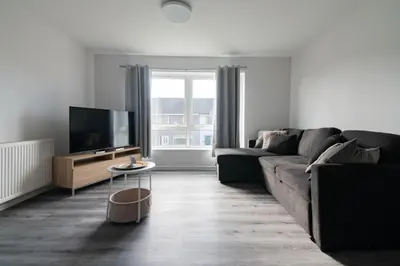 a living room with a couch and a flat screen tv at Renfrew House in Renfrew