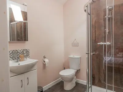 a bathroom with a toilet and a sink and a shower at Morton Mains Steading Cottage in Thornhill