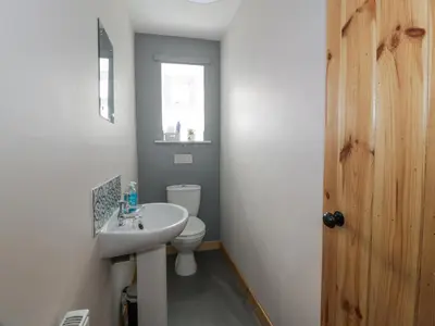 a bathroom with a white sink and a toilet at Morton Mains Steading Cottage in Thornhill