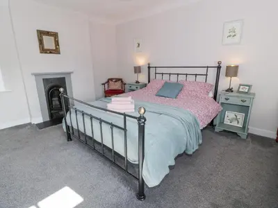 a bedroom with a bed and a fireplace at Morton Mains Steading Cottage in Thornhill