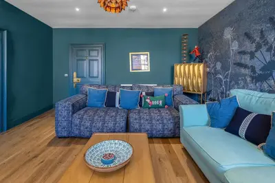 a living room with blue couches and a table at GuestReady - Unique hideaway in Edinburgh in Edinburgh