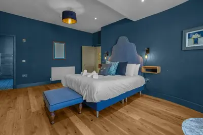 a blue bedroom with a bed and a blue wall at GuestReady - Unique hideaway in Edinburgh in Edinburgh