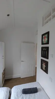 a white bedroom with a bed and a white door at The Dochart Lodge with hot tub Braidhaugh Crieff in Crieff