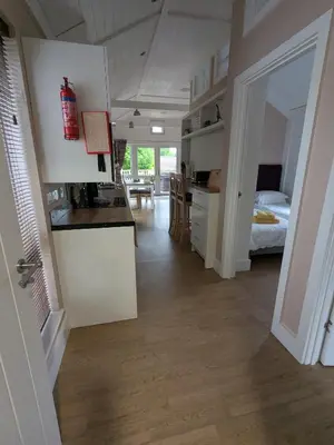 a room with a kitchen and a bedroom with a bed at The Dochart Lodge with hot tub Braidhaugh Crieff in Crieff