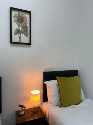 a bedroom with a bed and a table with a lamp at Squarezzz - Group Accommodation in Edinburgh