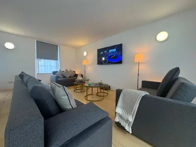 a living room with two blue couches and a table at Squarezzz - Group Accommodation in Edinburgh